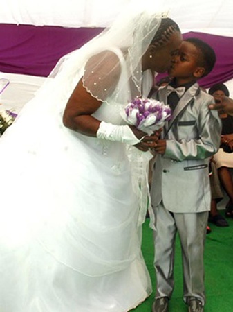 Bé trai 8 tuổi Sanele Masilela trao nụ hôn cho cô dâu 61 tuổi Helen Shabangu.  
